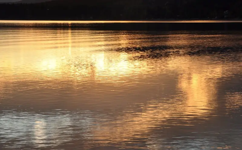 Sunset reflected on calm lake water in Vernon